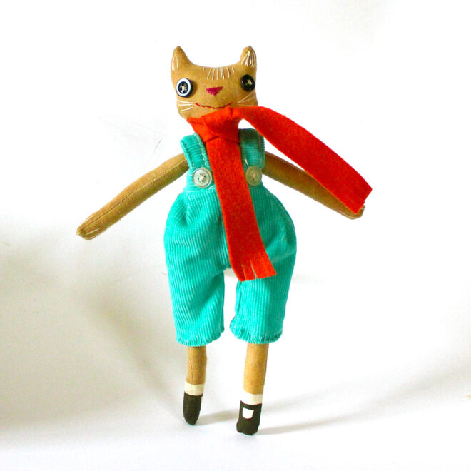 Coffee stained calico cat doll, wearing a pair of turquoise britches.