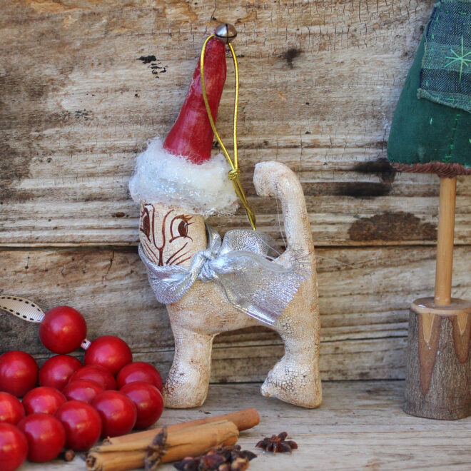 Vintage style Xmas decoration of a white cat with a red Santa hat.