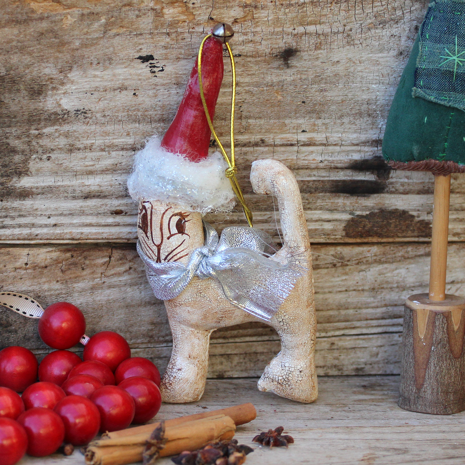 Vintage style Xmas decoration of a white cat with a red Santa hat.