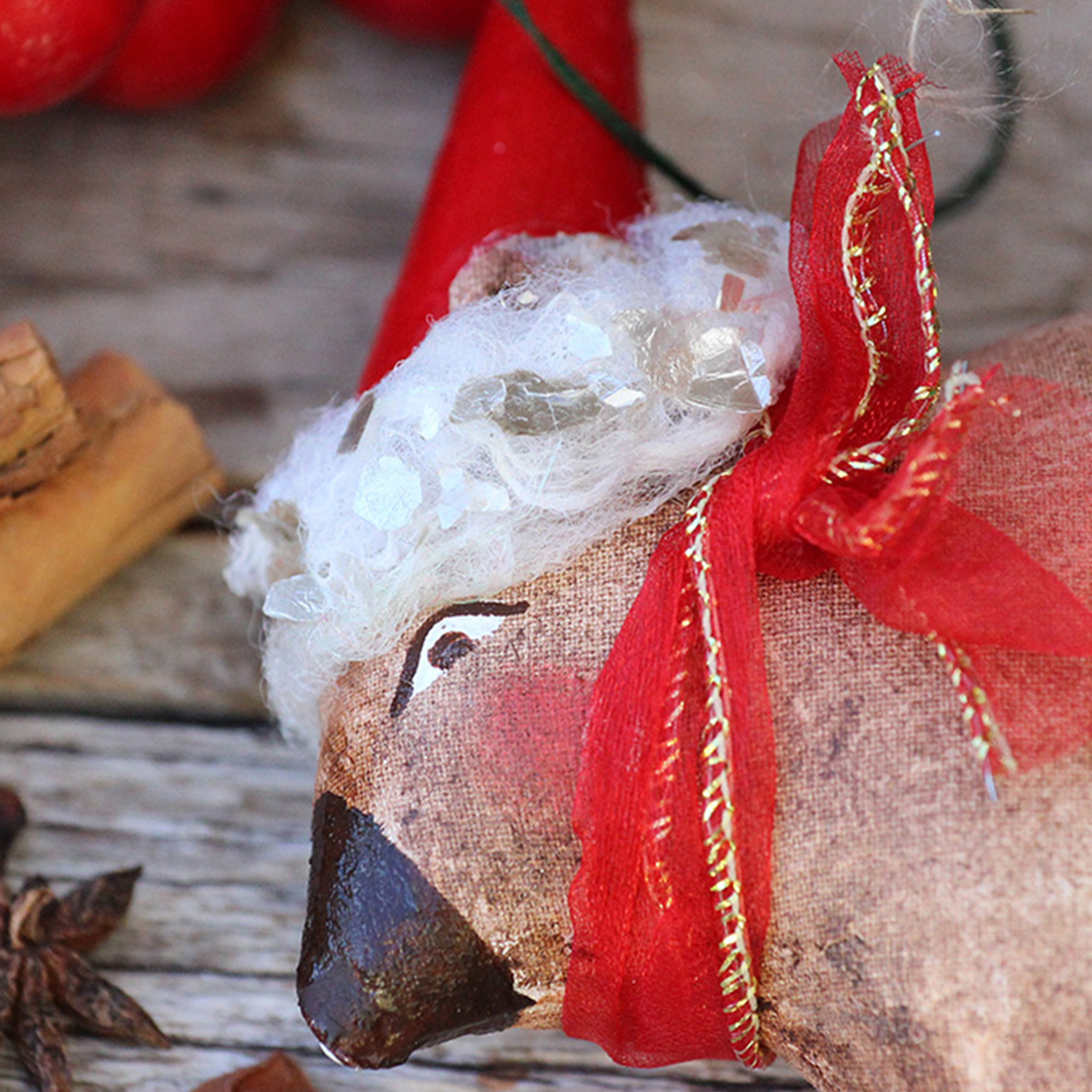 Small tree decoration, Santa Wombat. Brown wombat with a red Santa hat, red and gold ribbon. Four red button wheels are sewn to his feet.